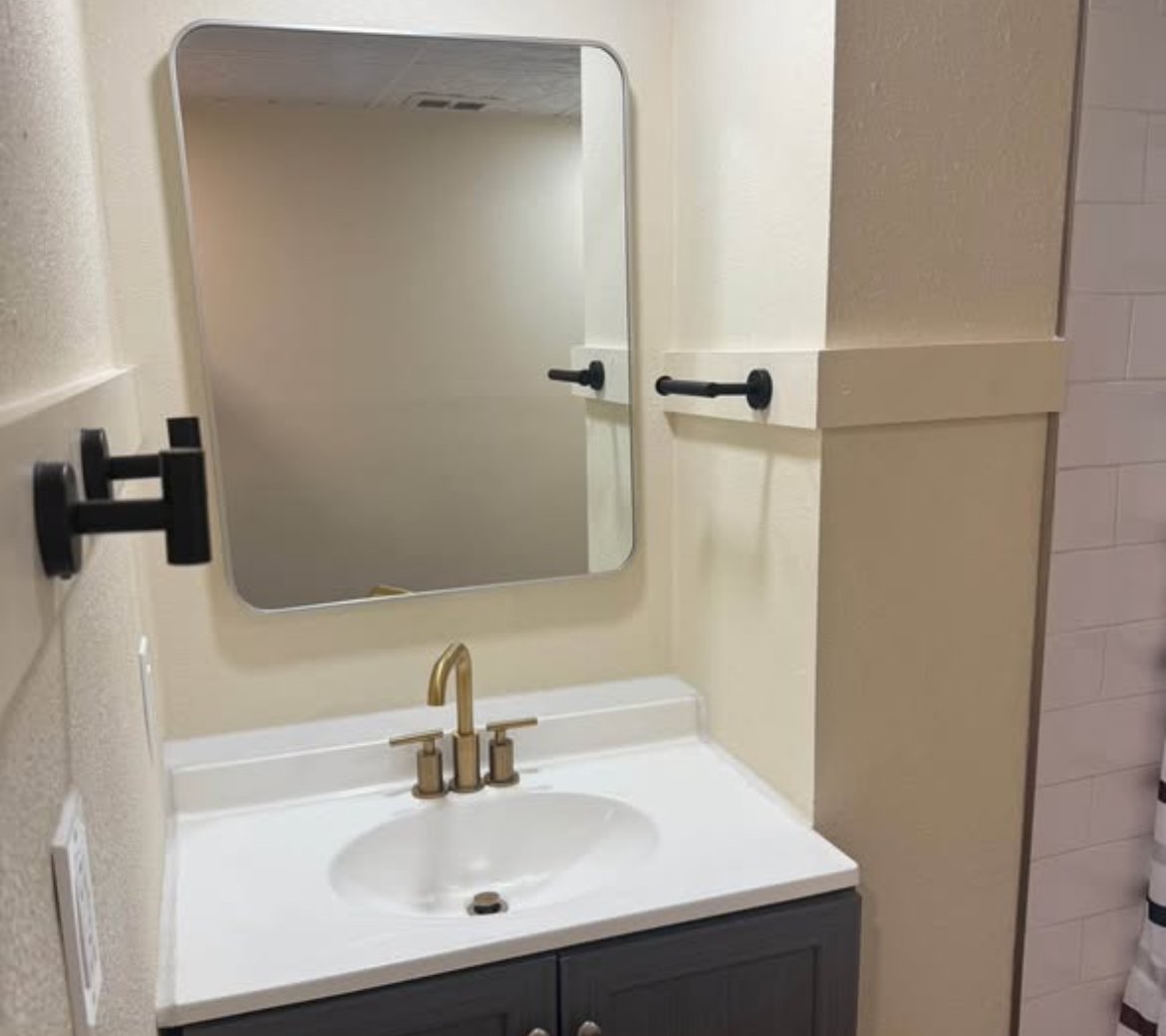 Bathroom vanity with dark cabinet, white countertop, and gold faucet at 1702 W Olive St