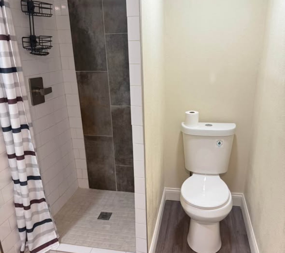 Bathroom with walk-in shower, subway tile, and toilet at 1702 W Olive St